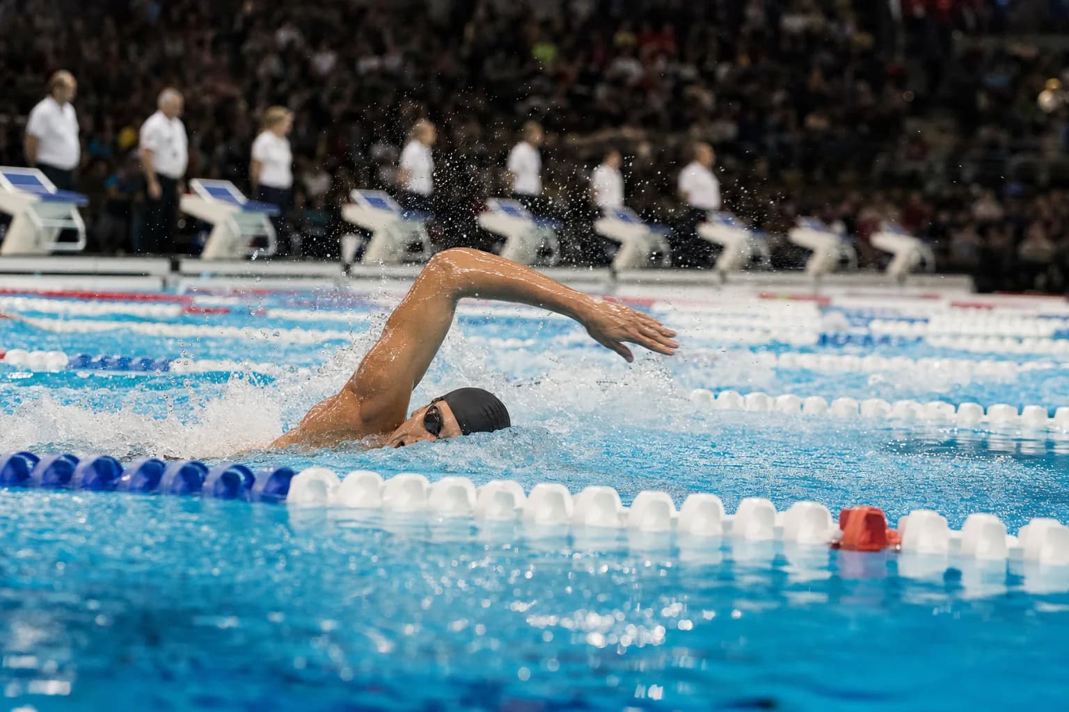 Nageur de compétition en crawl pendant une course en bassin