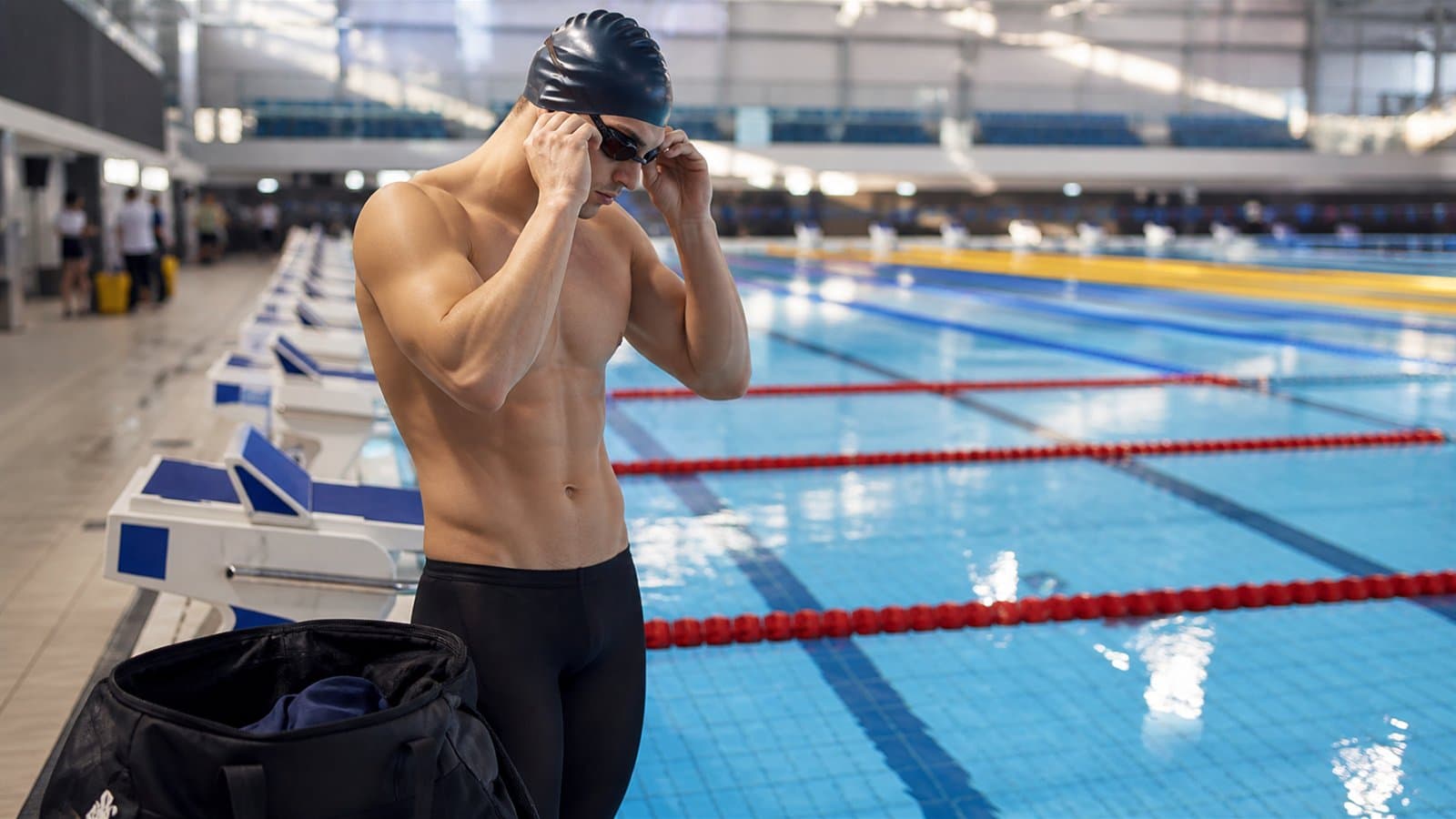 Nageur préparant ses lunettes au bord d'un bassin de compétition avant sa course.